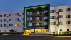 A modern hotel with a prominent 'element' sign, multiple floors, and a well-lit entrance.