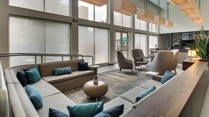 A spacious lobby with a large seating area, a reception desk, and a view of the outside.