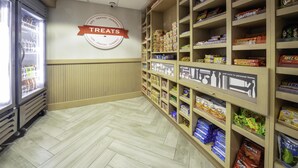Ein Geschäftsisle mit Regalen voller Snacks und einer Kühlvitrine.