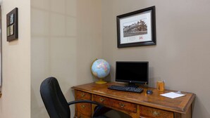 Un escritorio de madera con un globo terráqueo, un monitor de computadora y un teclado.