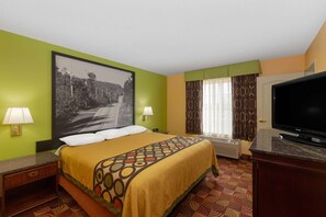 A hotel room with a bed, a television, a window with curtains, and a wall-mounted picture. - Super 8 by Wyndham Lake of the Ozarks (Eldon)