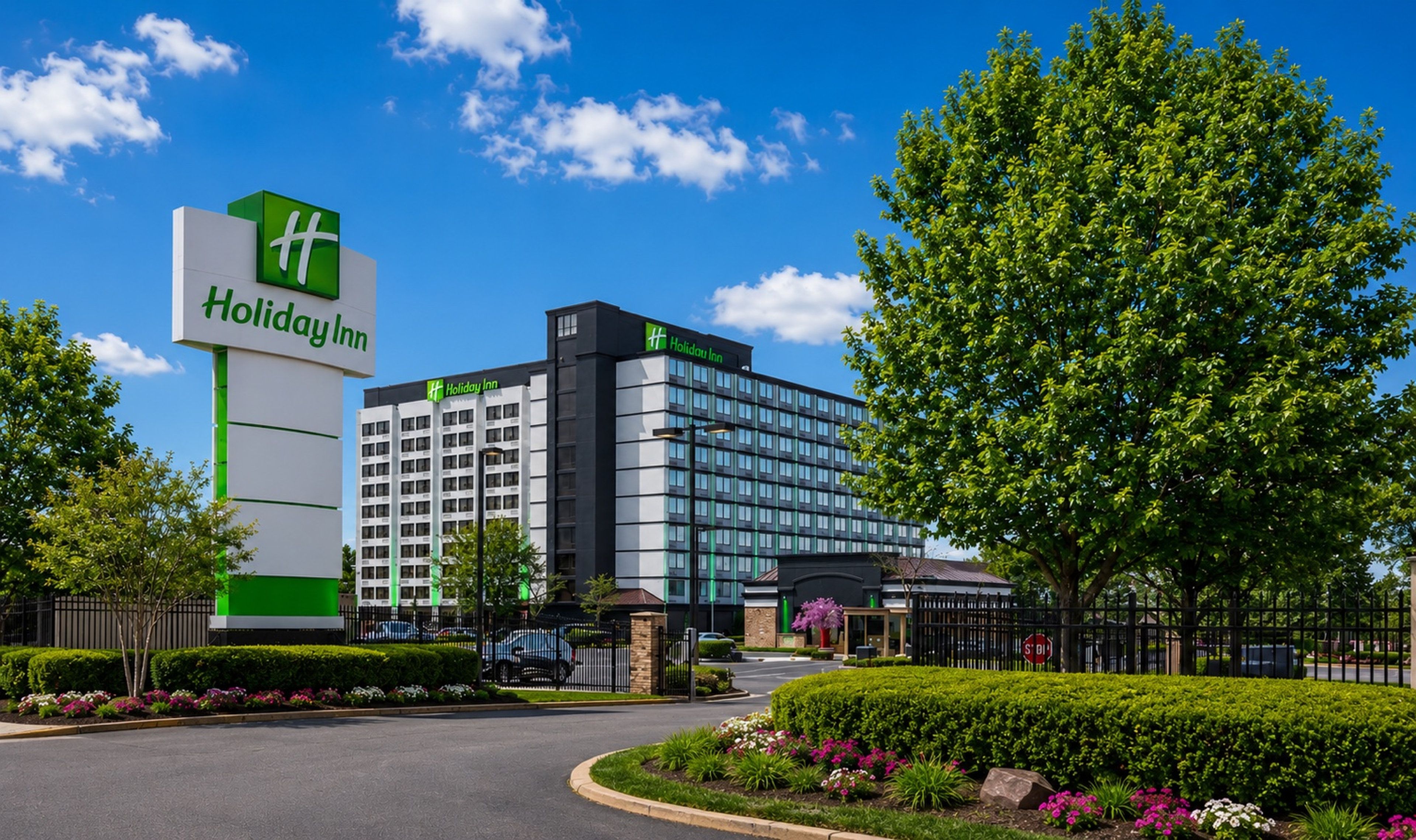 A Holiday Inn hotel with a prominent sign, a modern building facade, and well-maintained landscaping.