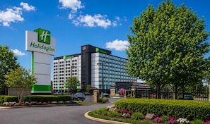 Ein Holiday Inn Hotel mit auffälliger Beschilderung, moderner Fassade und gepflegter Außenanlage.