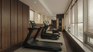 Un gimnasio con cintas de correr, una máquina de remo y una escaladora.