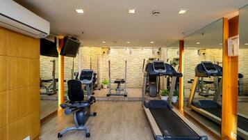 A gym with treadmills, a stationary bike, and a rowing machine.