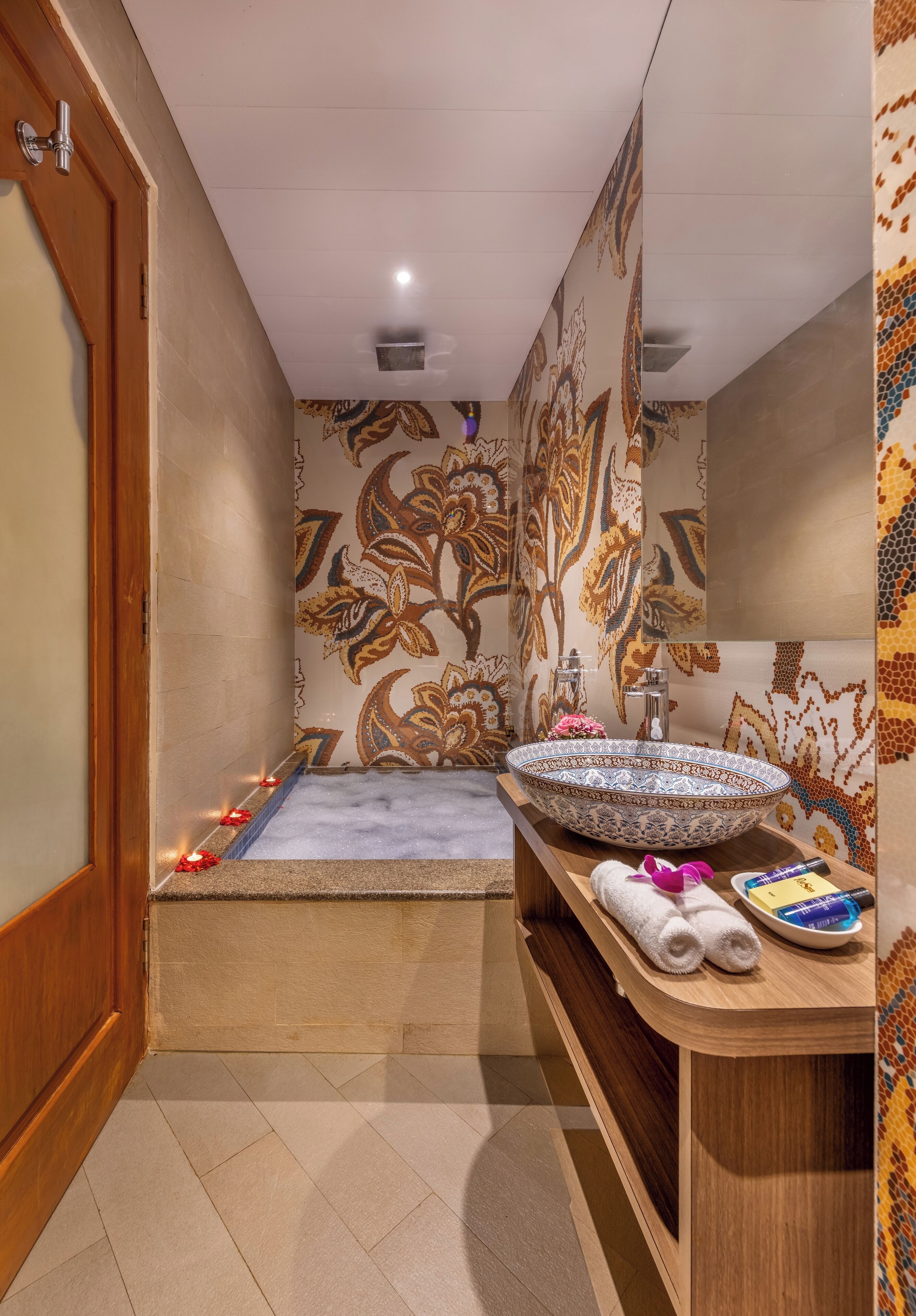 A bathroom with a bathtub, a sink, and a vanity with towels.