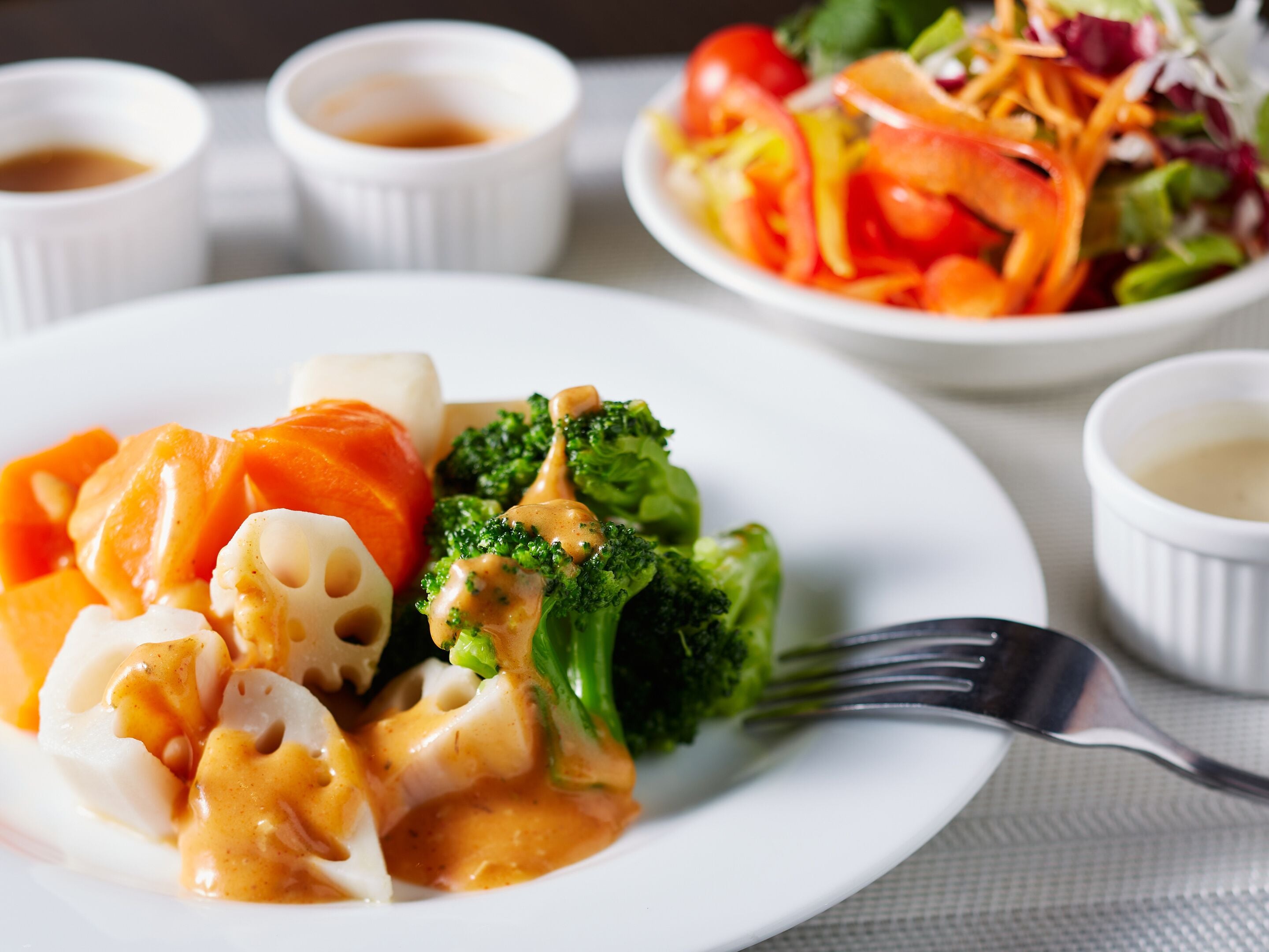 A plate of food with broccoli and carrots, and a fork on the side.