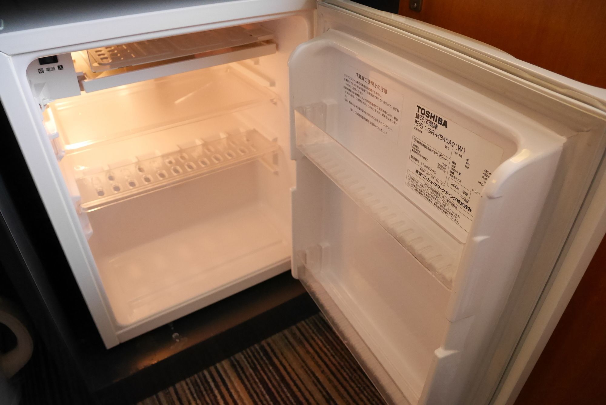 An open refrigerator with a label indicating it is a Toshiba model GR-BH40A2(W).