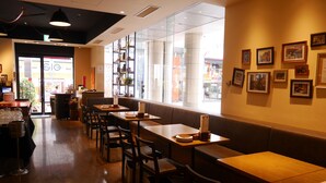 A restaurant interior with wooden tables, chairs, and a large window overlooking the street. - Sotetsu Fresa Inn Tokyo-Kamata (Tokyo)