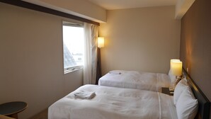 A hotel room with two beds, a small table, a lamp, and a window with curtains. - Sotetsu Fresa Inn Tokyo-Kamata (Tokyo)