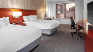 A hotel room with two beds, a desk, a chair, a TV, and a window with a city view. - Courtyard by Marriott Downtown Memphis (Memphis)