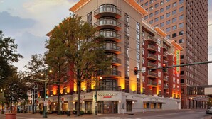 A Courtyard by Marriott hotel with multiple balconies, a prominent entrance, and a large tree in front. - Courtyard by Marriott Downtown Memphis (Memphis)
