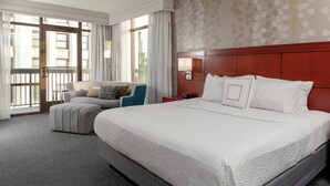 A hotel room with a large bed, a sofa, a chair, and a desk. - Courtyard by Marriott Downtown Memphis (Memphis)