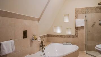 A modern bathroom with a freestanding bathtub, a glass-enclosed shower, and a toilet.