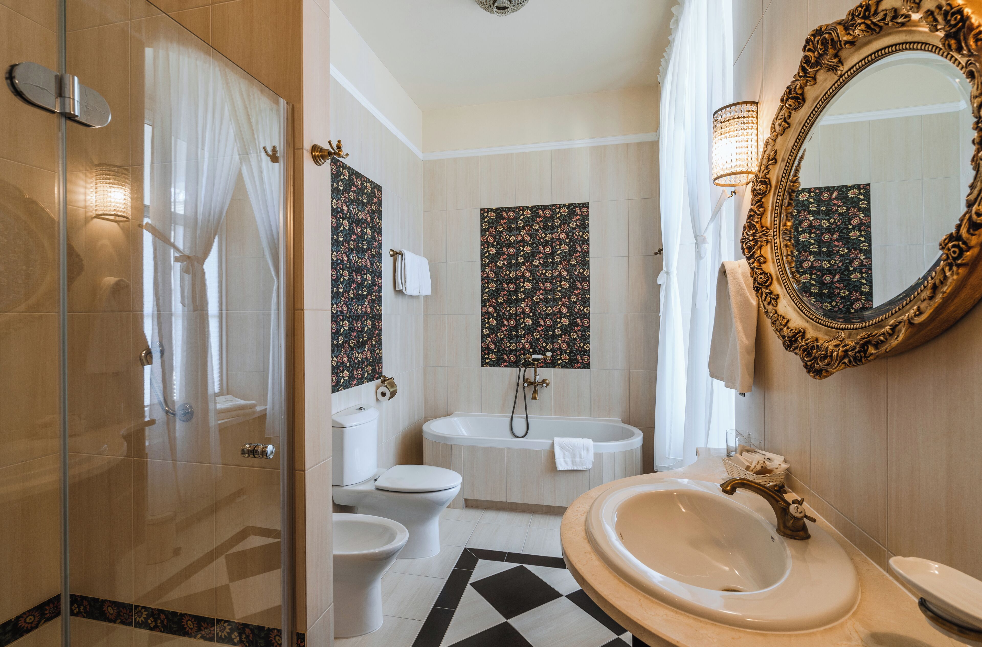 Un baño con mampara de vidrio, inodoro, bañera y lavabo con espejo.