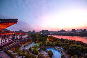 A resort with a swimming pool, landscaped gardens, and traditional architecture. - Shangri-La Guilin (Guilin)