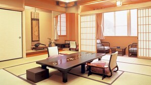 Una habitación japonesa tradicional con suelo de tatami, una mesa baja y paneles shoji.