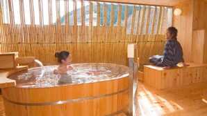 Un interior de madera con un jacuzzi, asientos de madera y una pared de bambú.