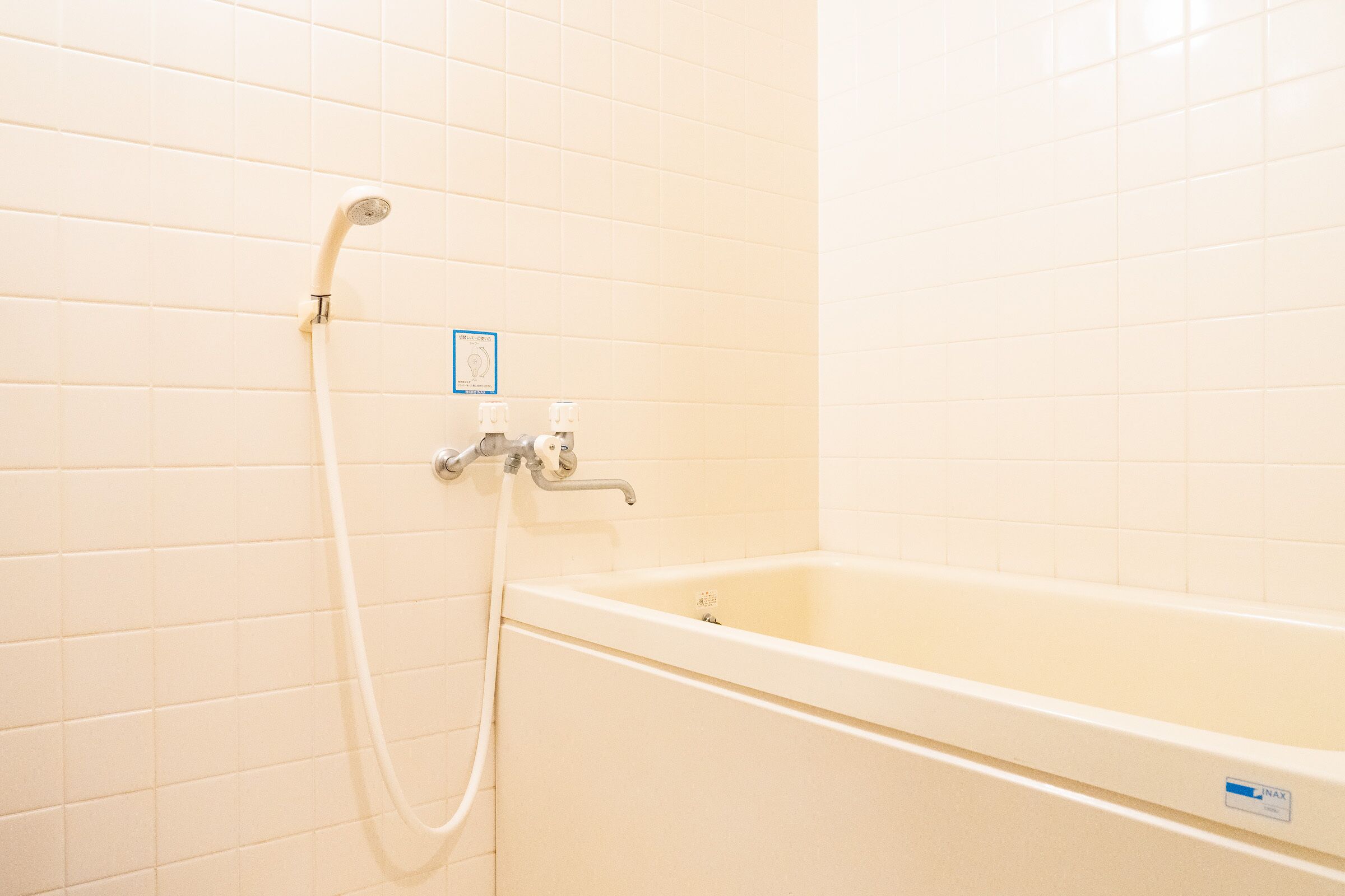Un baño con bañera, ducha y panel de control en la pared.