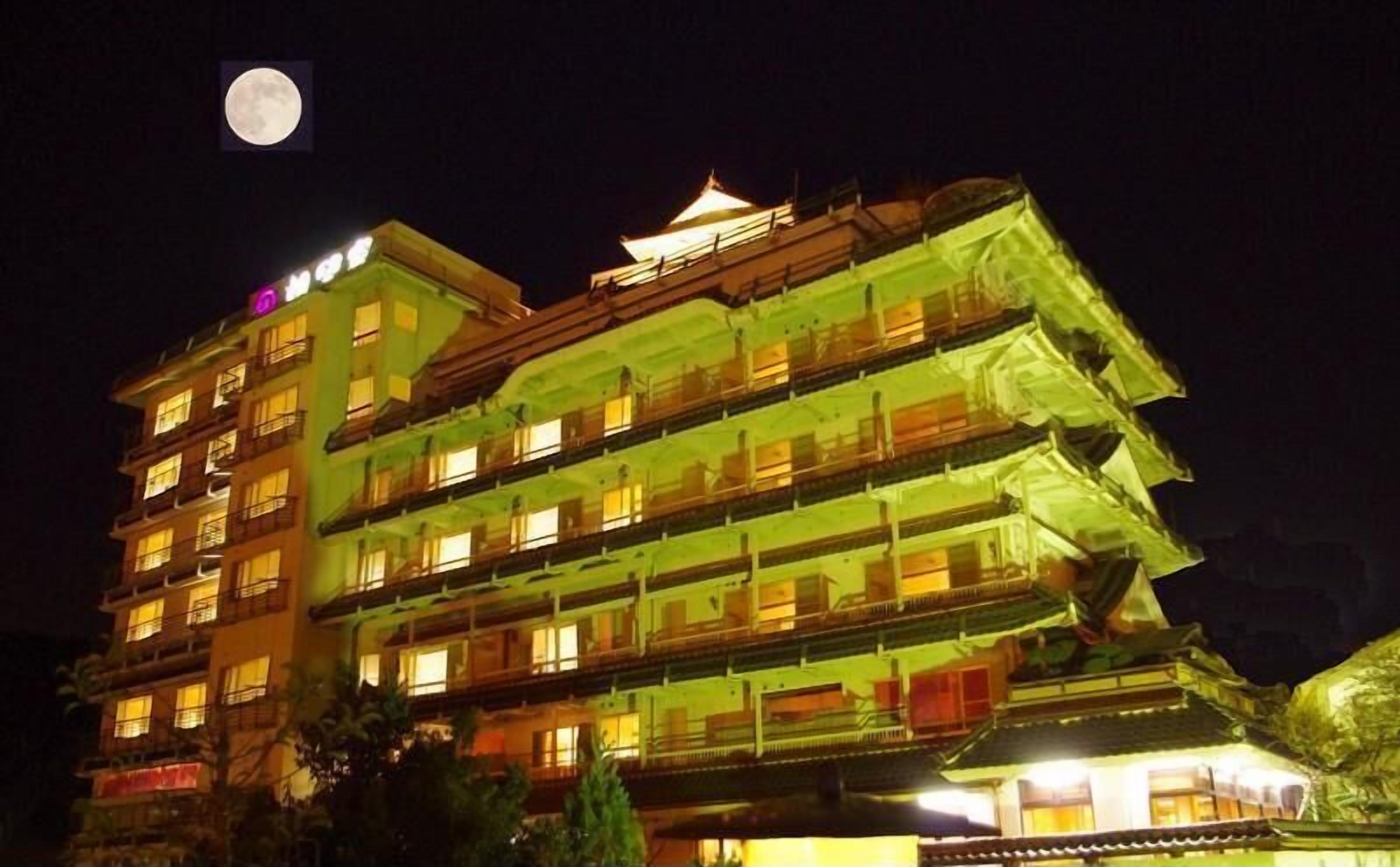 A multi-story building with traditional architecture, illuminated at night.