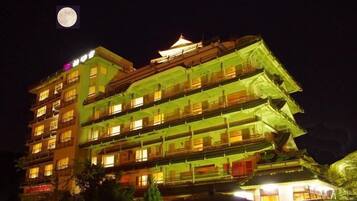 A multi-story building with traditional architecture, illuminated at night.