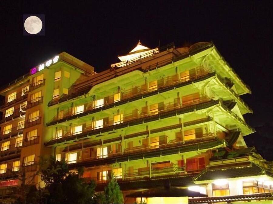 A multi-story building with traditional architecture, illuminated at night.