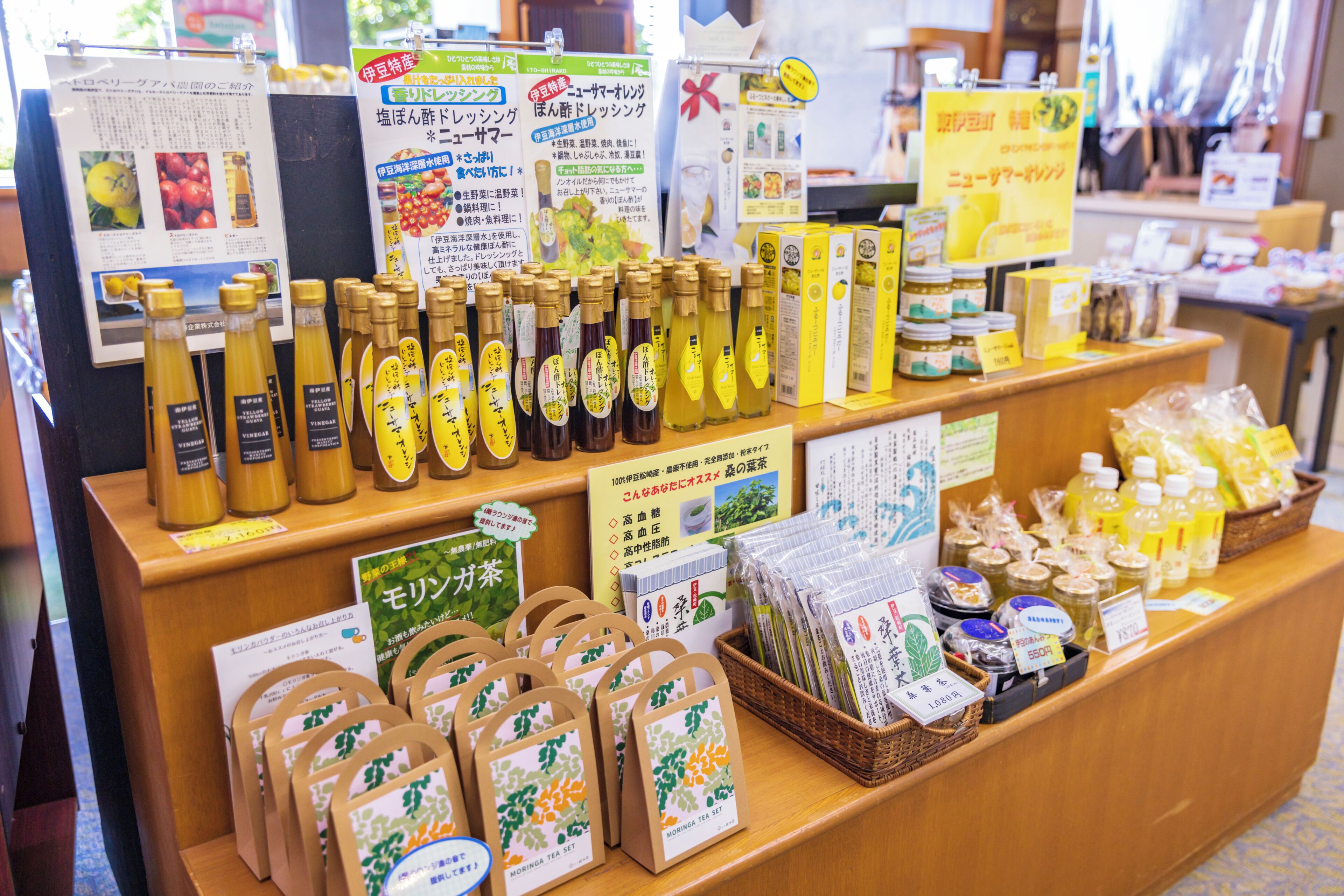Une exposition de divers produits, notamment des bouteilles, des services à thé et des produits emballés, probablement dans un magasin ou sur un marché.