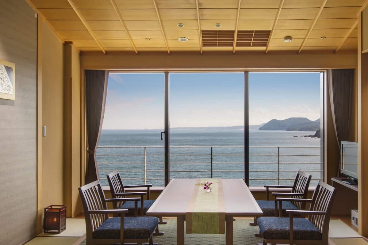 A room with a large window, a table, and four chairs.