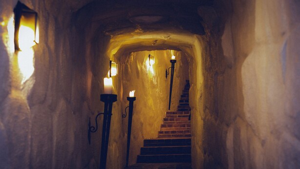 A narrow stone staircase with candle sconces on either side, leading to an upper level. - Häringe Slott (Vasterhaninge)