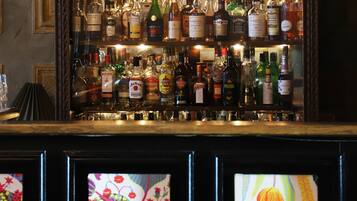 Zona de bar con estantes llenos de diferentes botellas de licores.