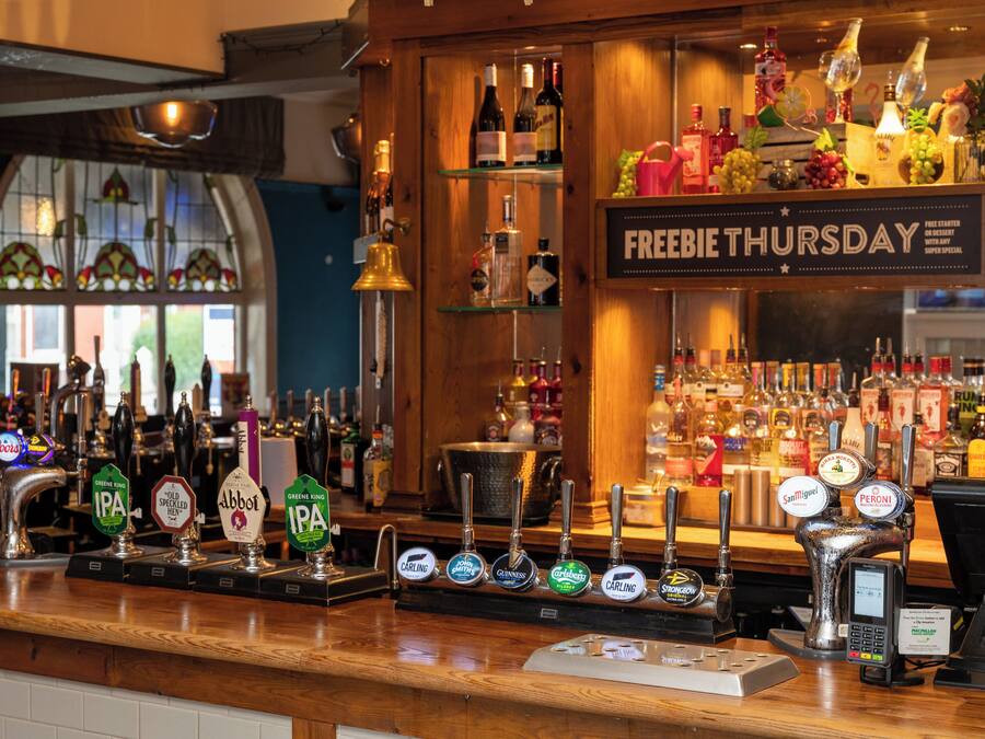 A bar with multiple beer taps and a sign for Freebie Thursday.