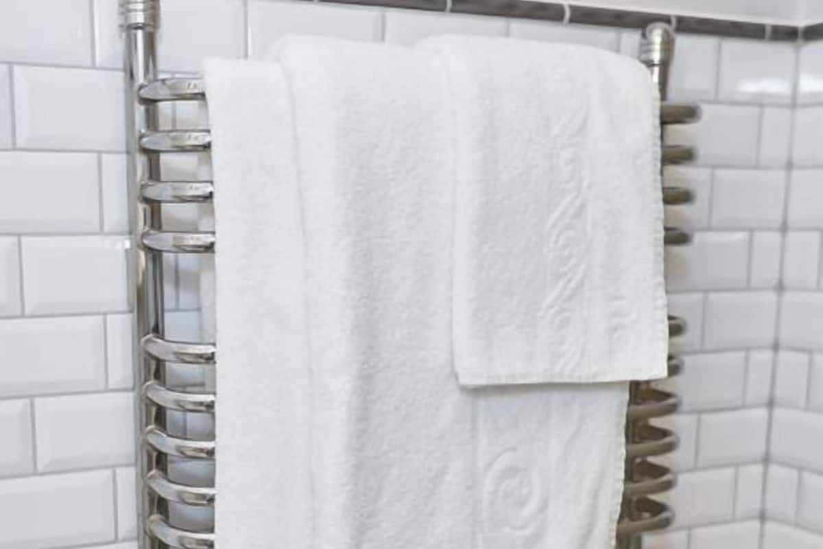 A bathroom with a white towel hanging on a metal towel rack.