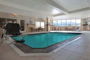 Une piscine équipée d’un poste de surveillance pour sauveteur, d’un fauteuil roulant et d’une chaise avec un dossier.