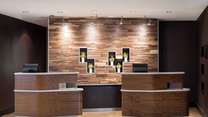 A reception area with two wooden reception desks, a wall with wooden panels, and recessed lighting. - Courtyard by Marriott Glenwood Springs (Glenwood Springs)