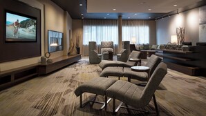 A modern living room with a large flat-screen TV, comfortable seating, and a patterned carpet. - Courtyard by Marriott Glenwood Springs (Glenwood Springs)
