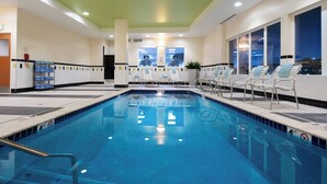 A swimming pool with a 4ft depth limit, surrounded by lounge chairs and a sunbed area.