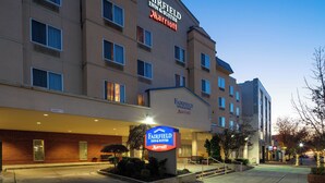 A Fairfield Inn & Suites by Marriott hotel with a clear sign, a brick facade, and a well-lit entrance.