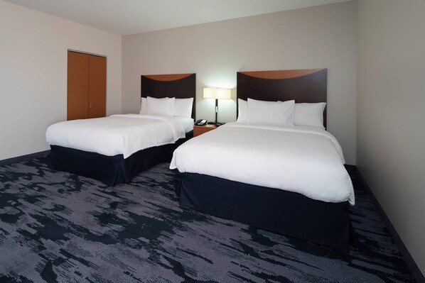 A hotel room with two beds, a nightstand with a lamp, and a door. - Fairfield Inn & Suites Seattle Bremerton (Bremerton)