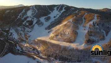 A mountainous landscape with a ski resort, including ski trails and a lodge.