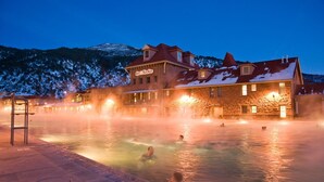 Un spa con edificio de piedra y zona de aguas termales.
