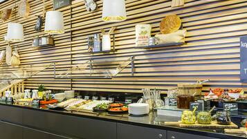 A buffet area with various food items and condiments.