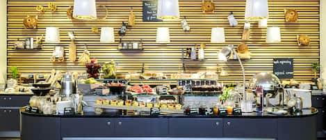 A buffet counter with various food items and kitchenware.