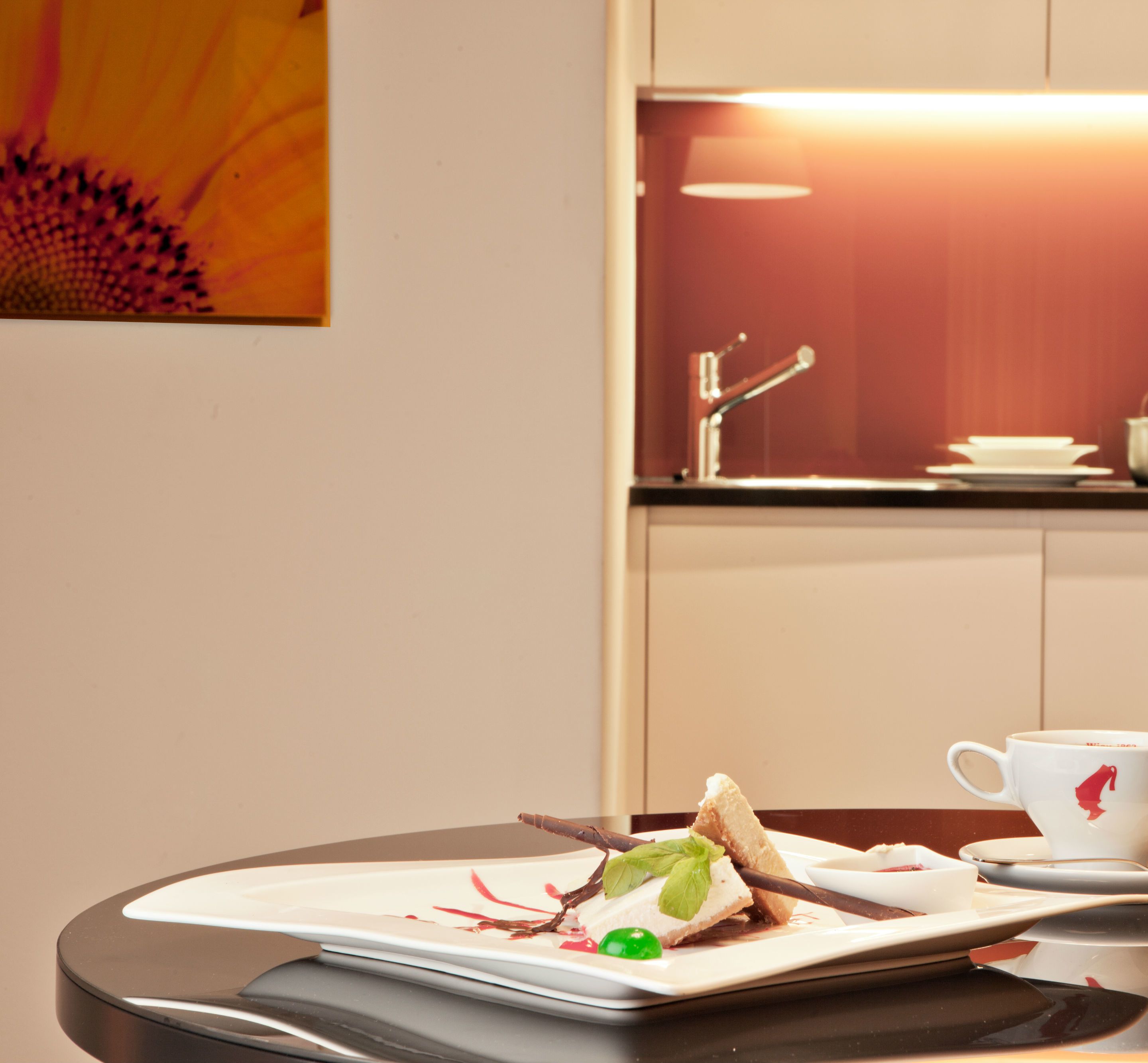 A breakfast setting with a sandwich, a cup, and a plate on a table.