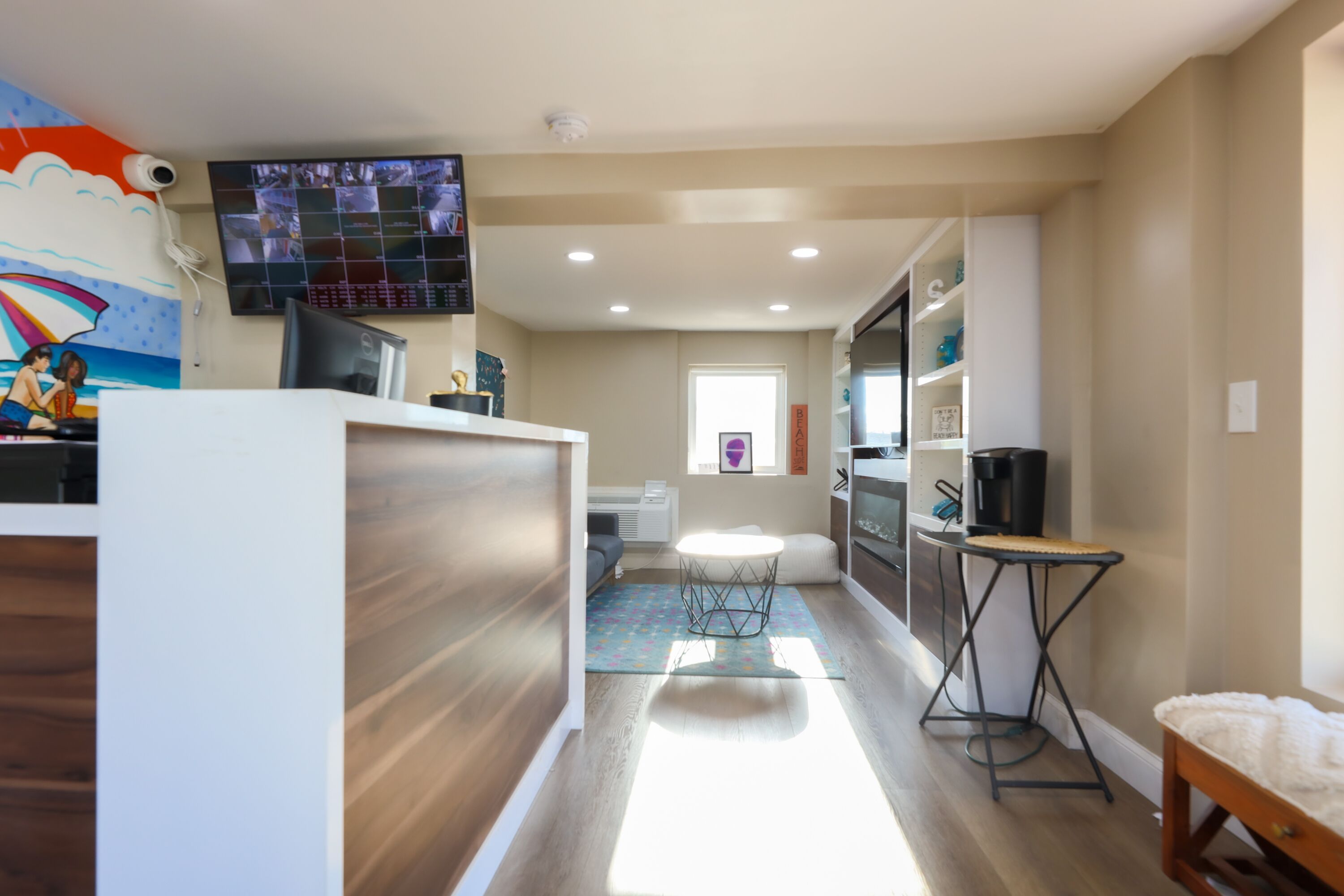 Eine moderne Küche mit großem Fernseher, Holzböden und einer kleinen Essecke mit rundem Tisch und Hockern.