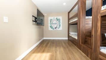Una habitación con literas de madera, un espejo y un cuadro en la pared.