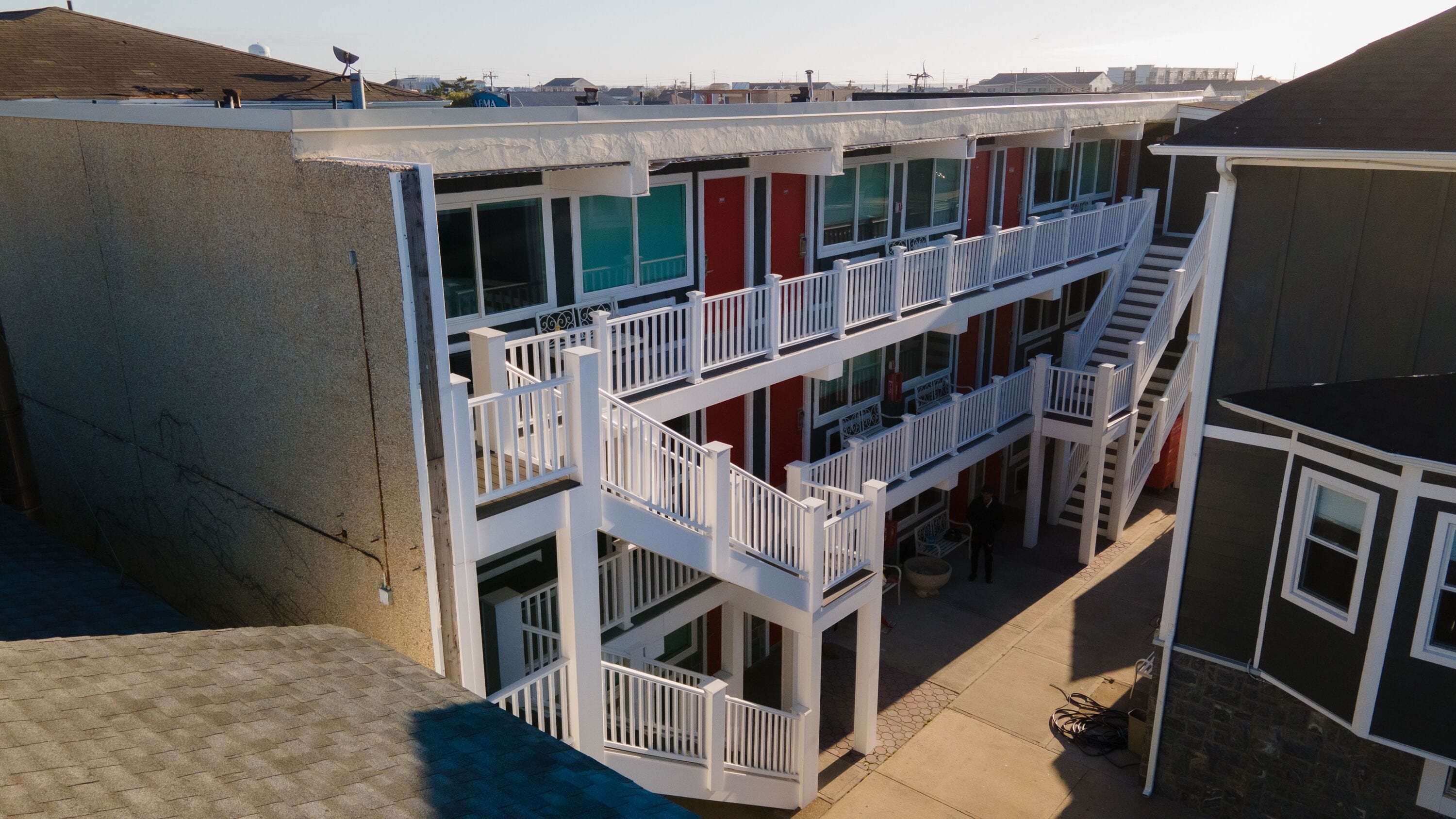 Un edificio de varios pisos con un patio central, balcones y una escalera que conecta los pisos.