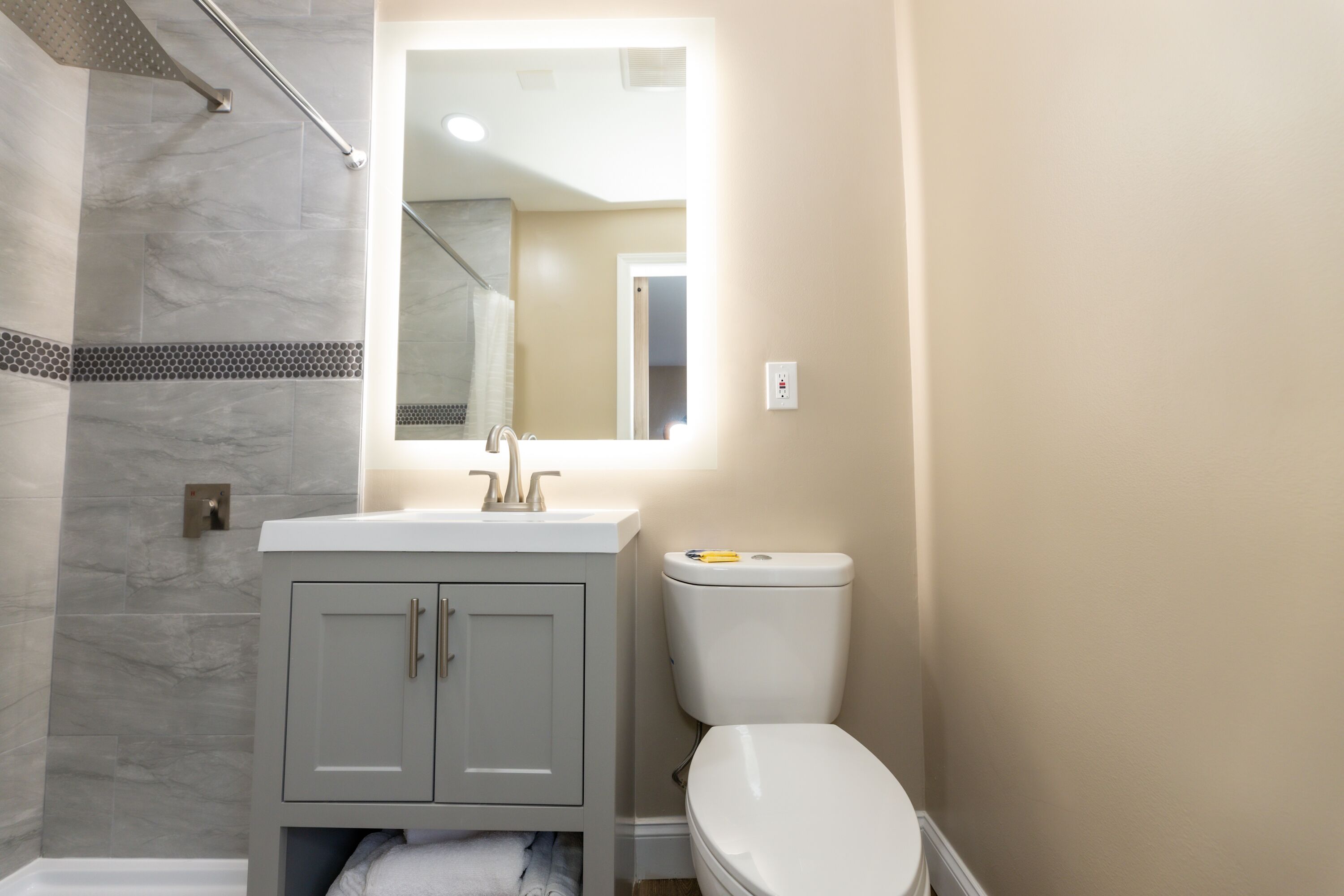 Une salle de bain avec un lavabo blanc, des toilettes et un espace douche.