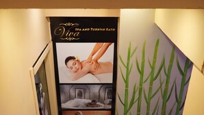 Una escalera con publicidad de spa y baño turco, arte mural de bambú y suelo de baldosas.