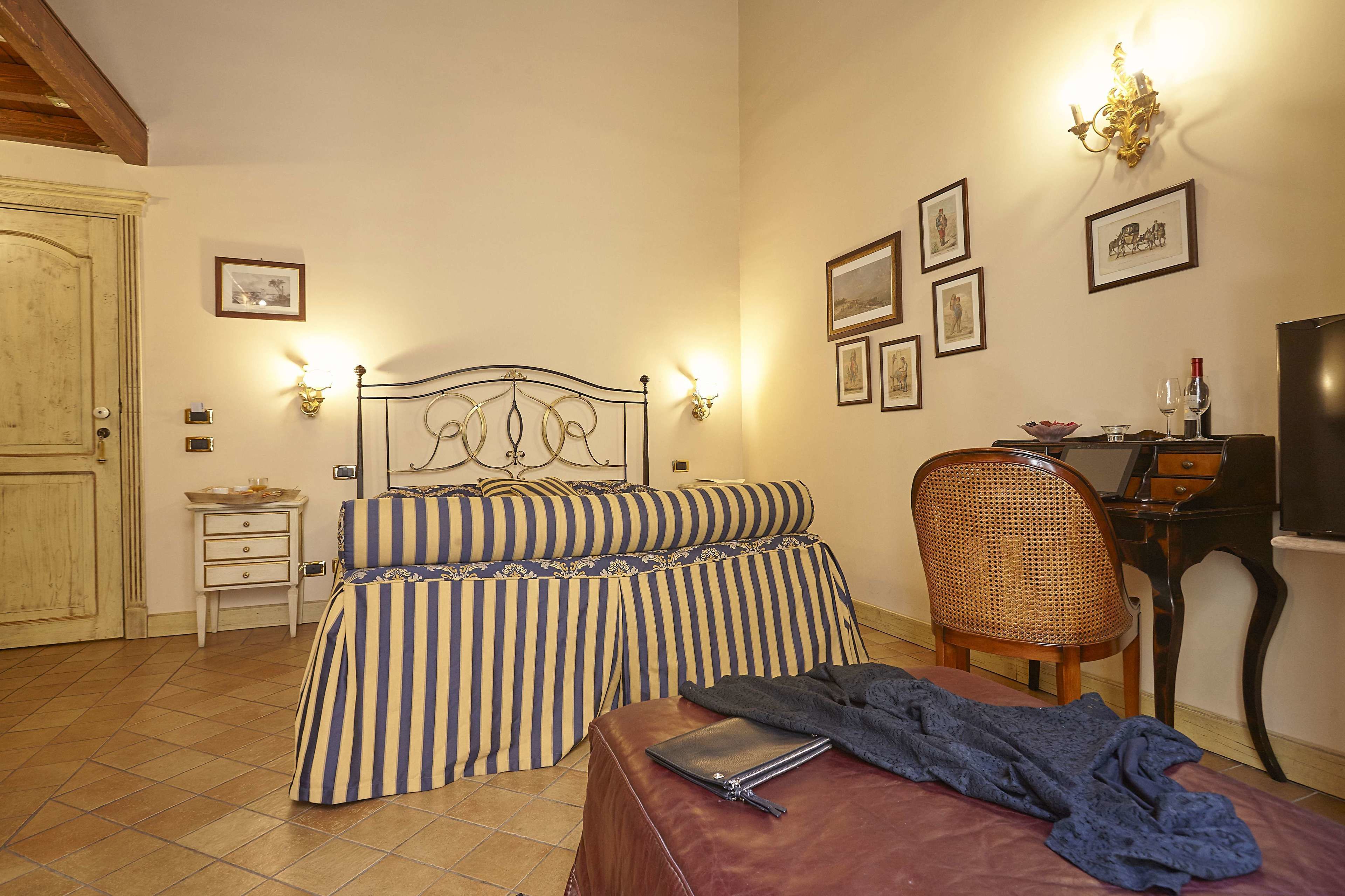 A bedroom with a bed, bedside tables, a desk, and a chair.