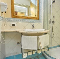 Un bagno con lavandino, specchio e doccia.
